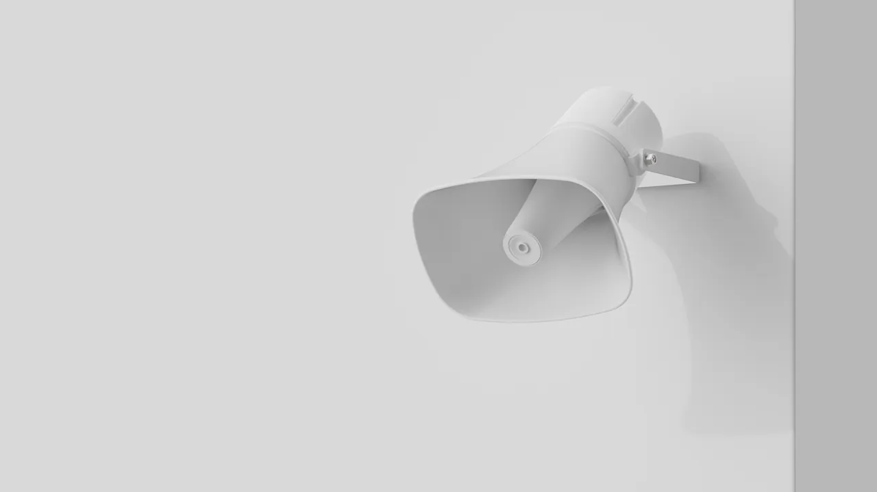 White Verkada horn speaker alarm mounted on a light grey wall.
