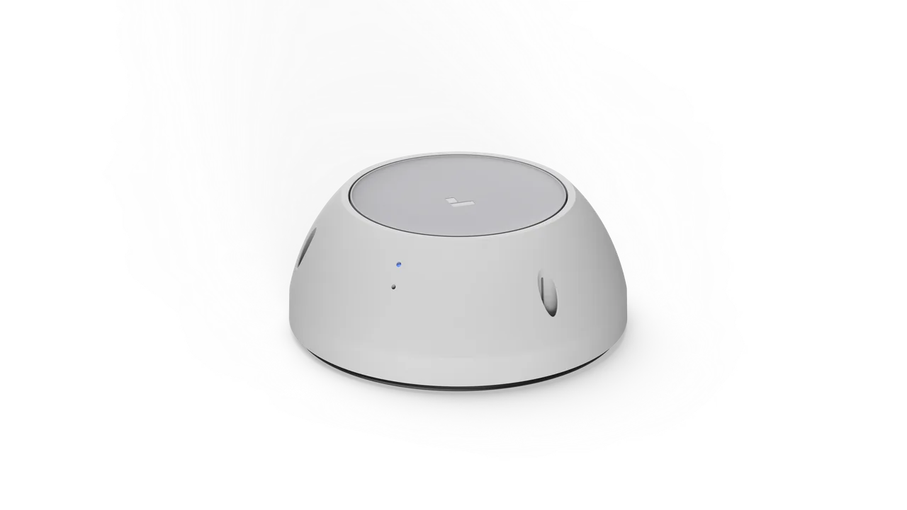 Dome-shaped white fire alarm monitoring device with a blue LED indicator and side vents, shown against a light gray.