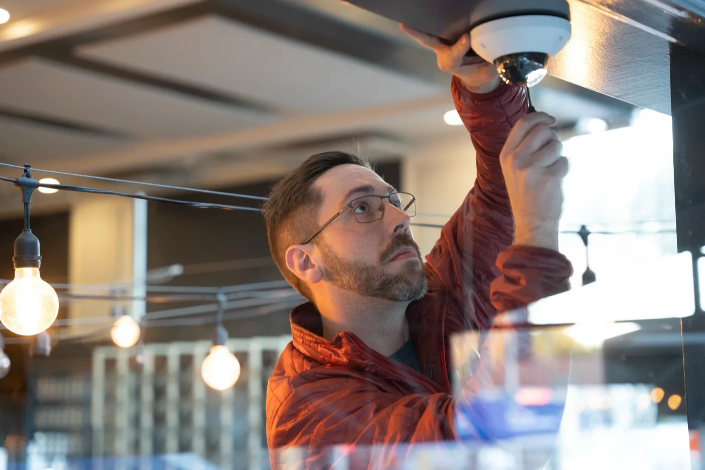 technician installing a retail security camera for store loss prevention