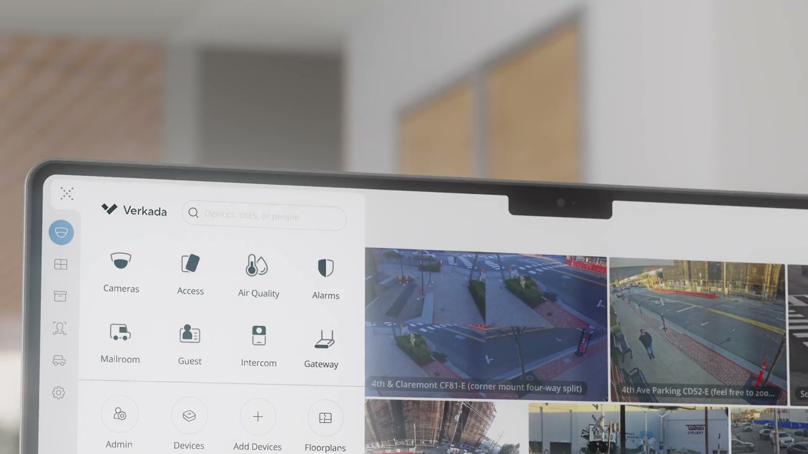 The Verkada Command dashboard on a laptop, showing live camera feeds and the product line