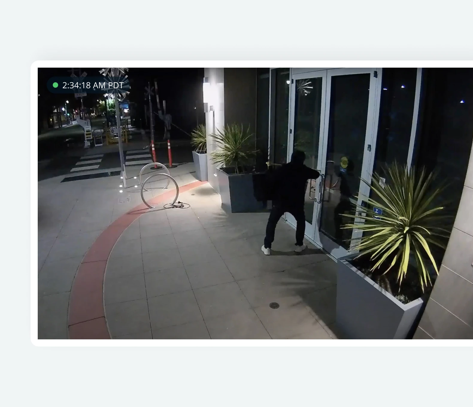 Man breaking into business as captured by live video monitoring