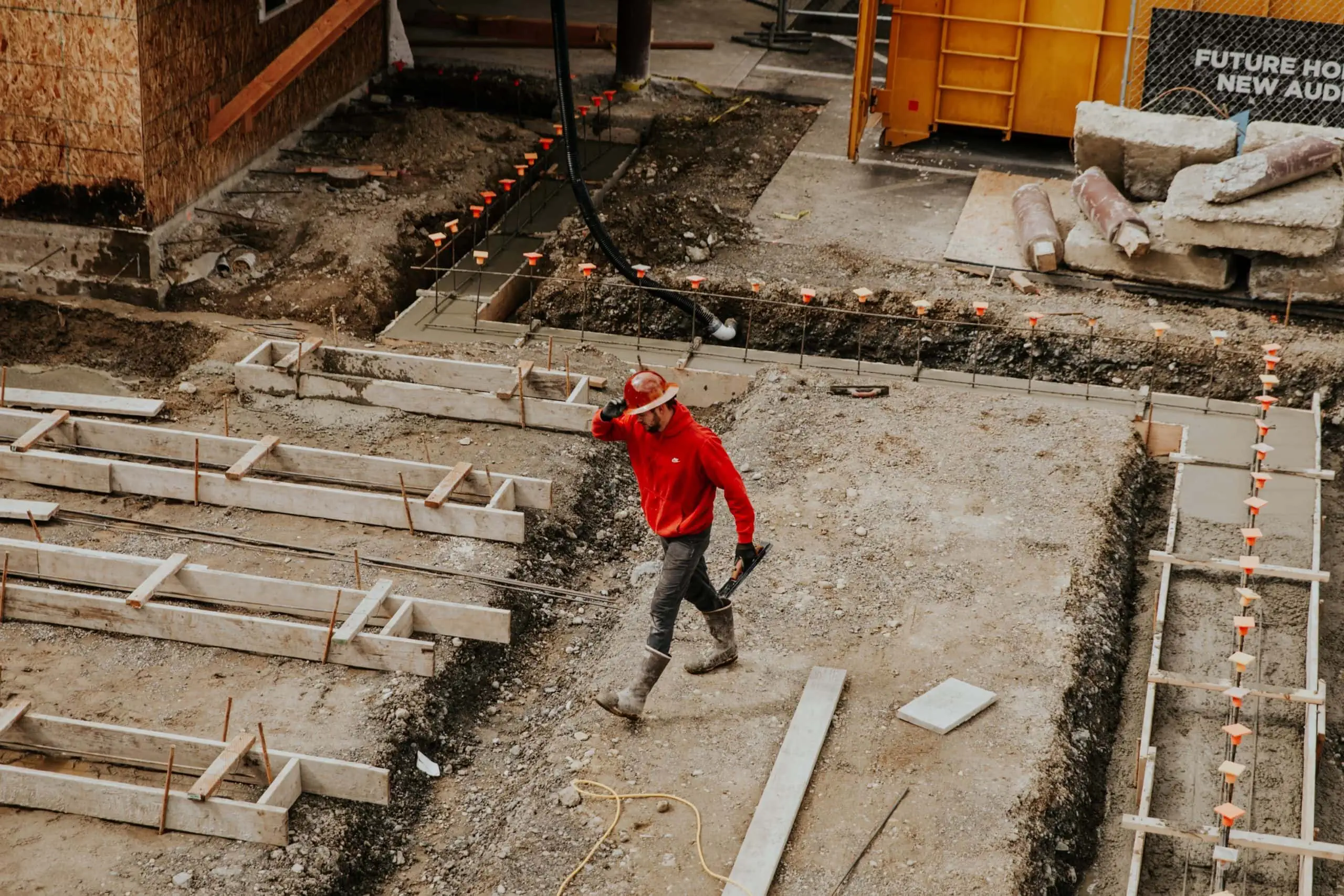 Employee walking through construction site that is monitored by jobsite security cameras