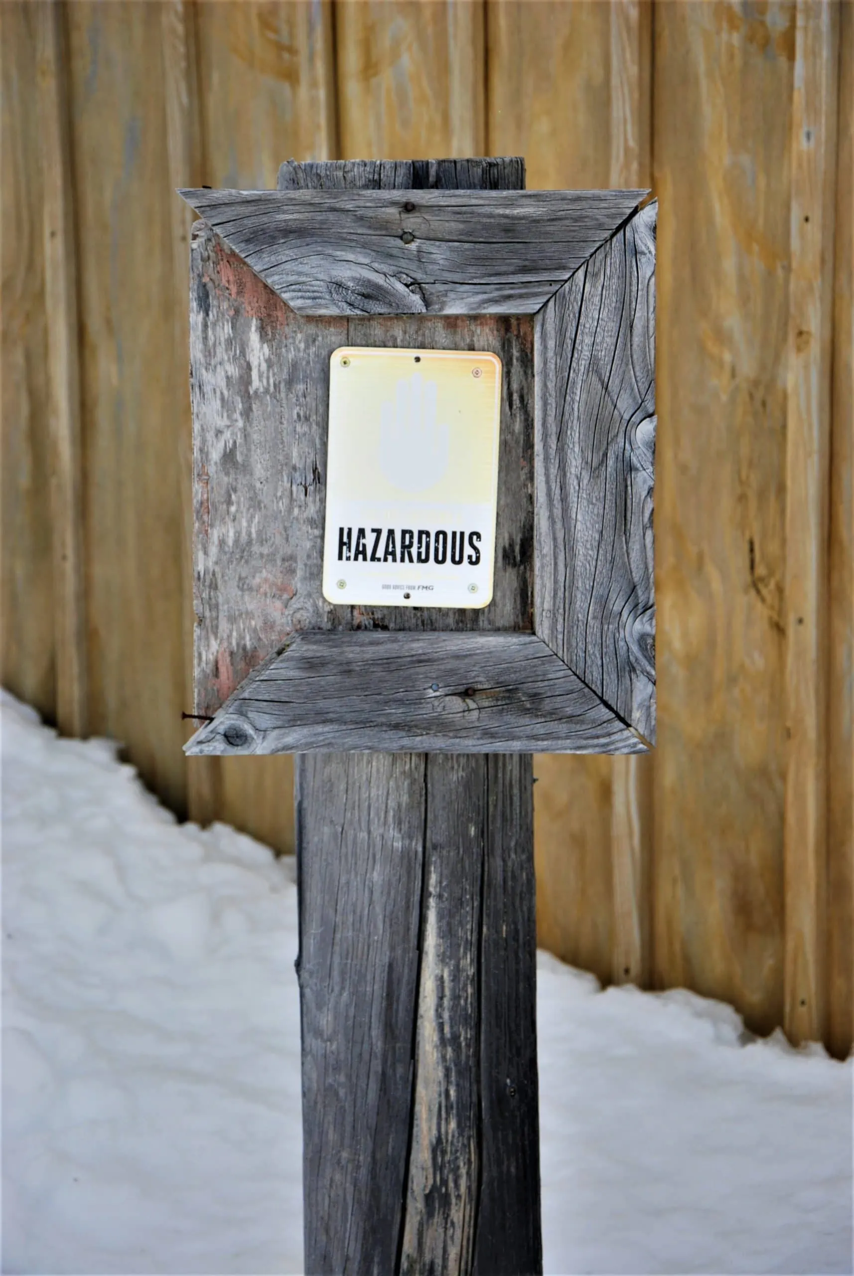 Signpost indicating hazardous conditions on job site that are monitored by construction security camera