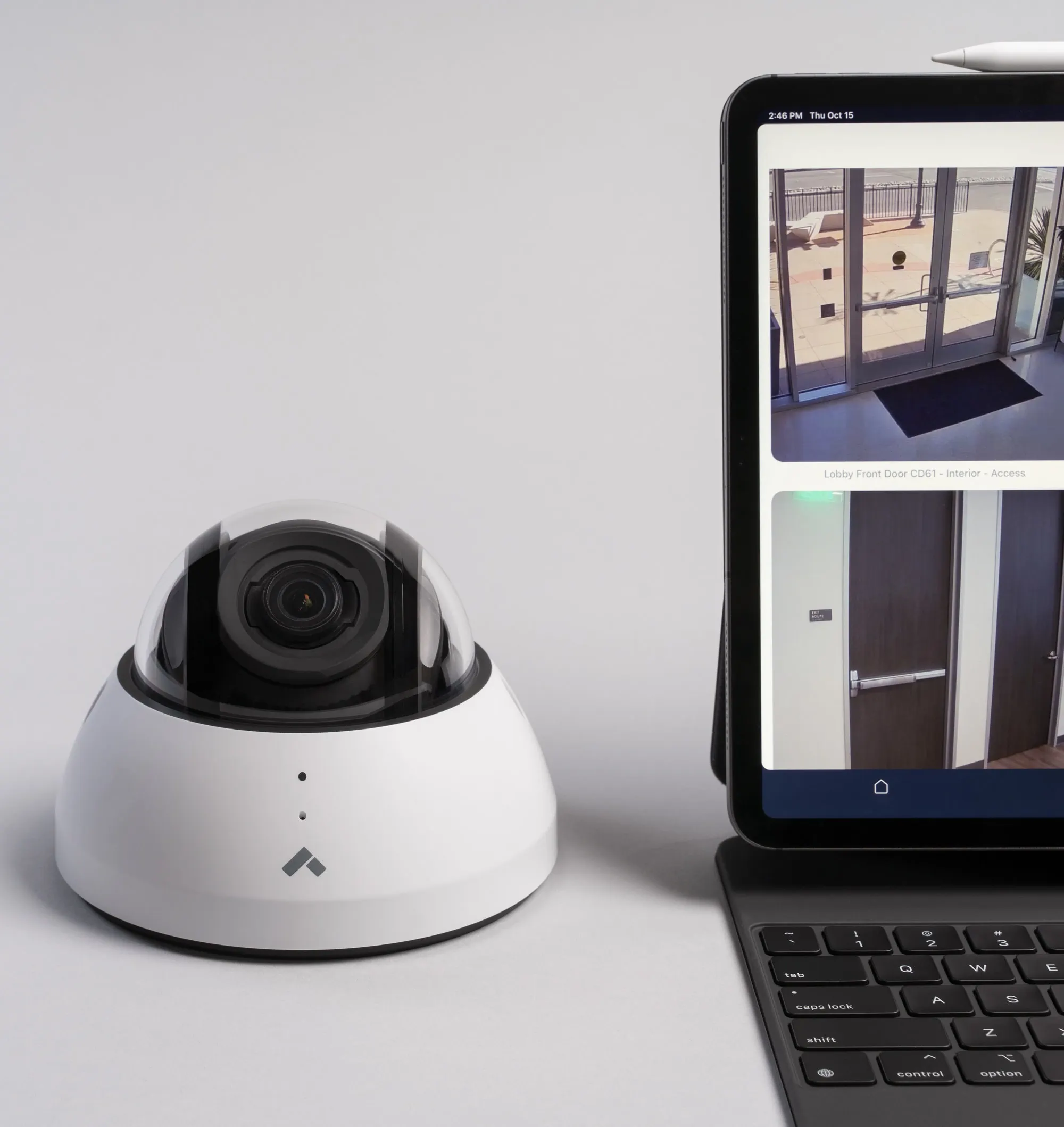 Verkada dome camera next to a laptop serving a surveillance monitor