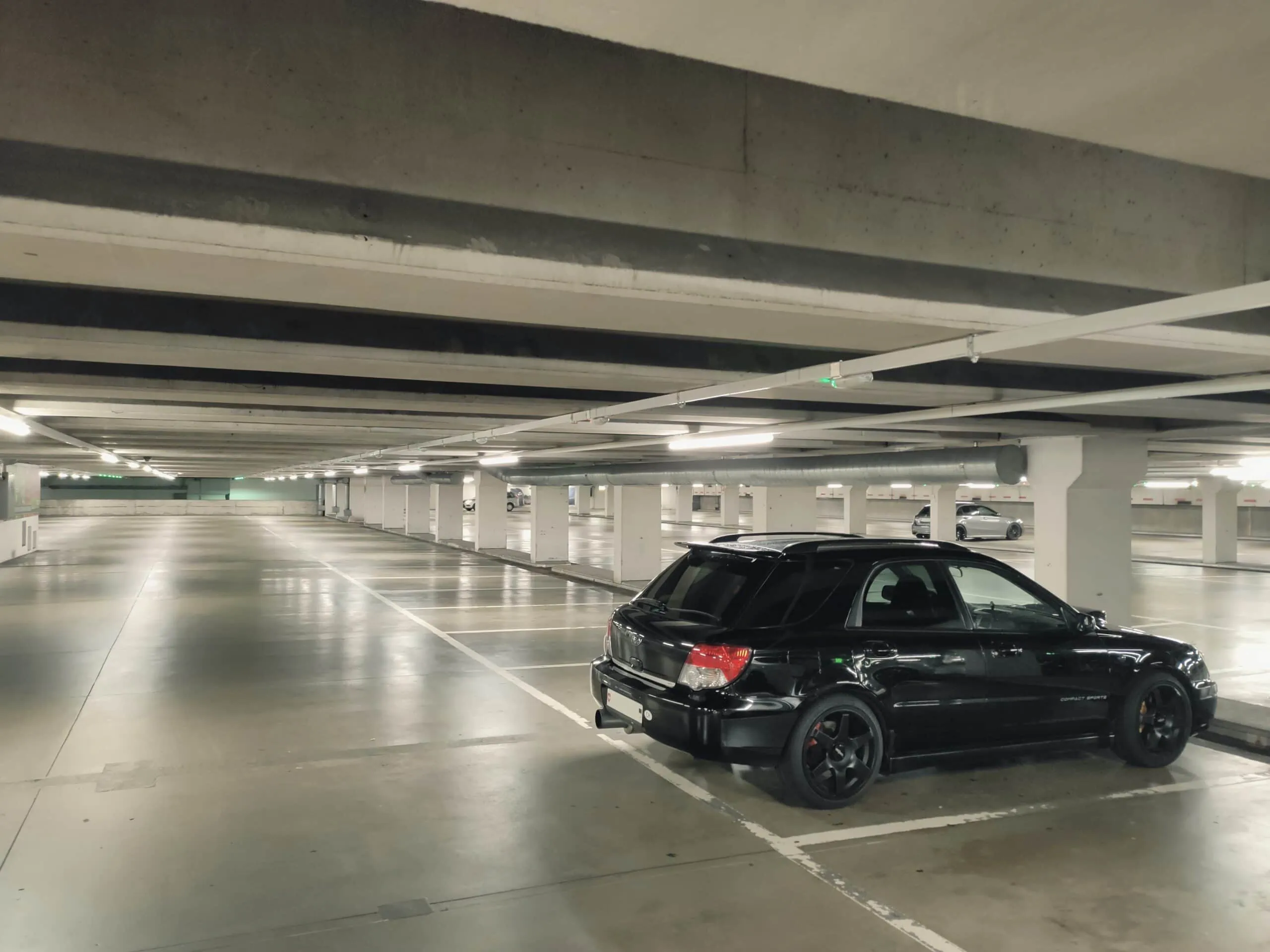 Car in parking garage protected by surveillance cameras