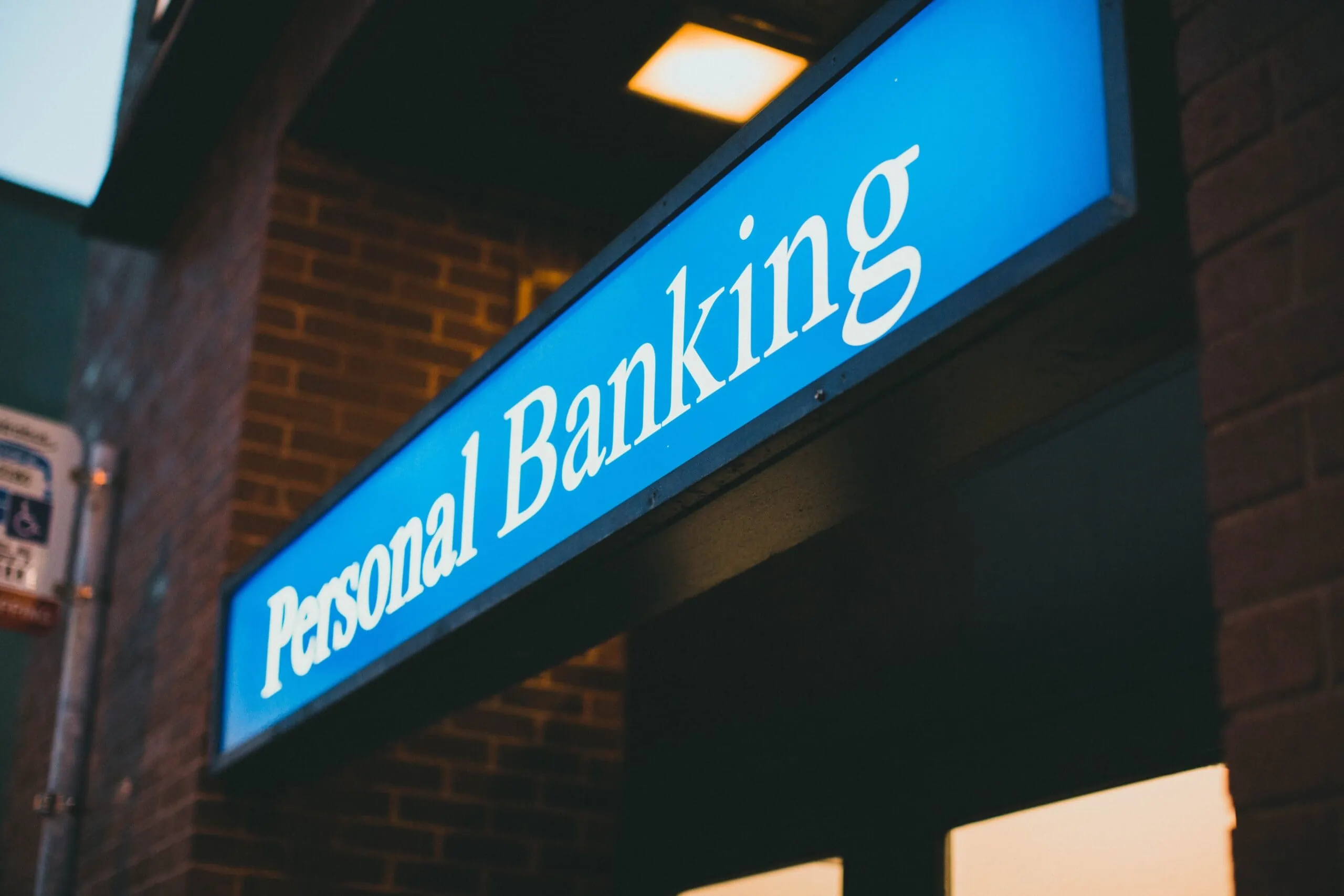 Sign that reads “personal banking” outside of a bank equipped with security cameras