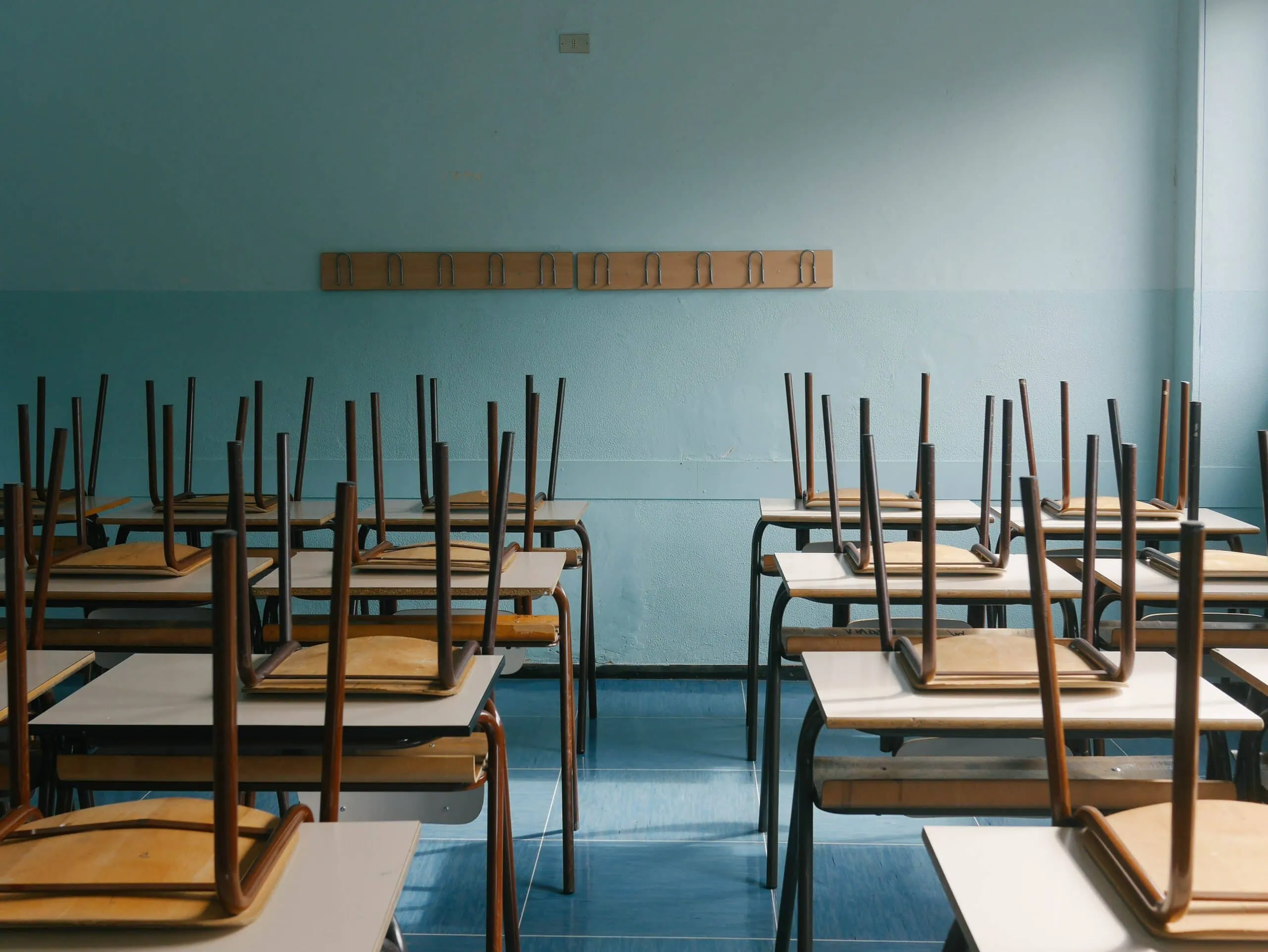 Chairs stacked on desks in classroom that detects vape with cigarette smoke detectors