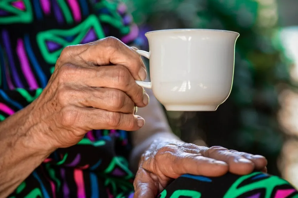 Elderly woman drinking tea in assisted living facility that allows cameras