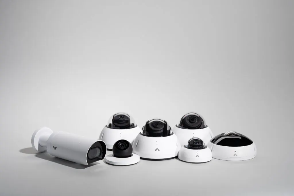 A collection of white IP cameras captured against a plain grey backdrop highlighting the NVR meaning.