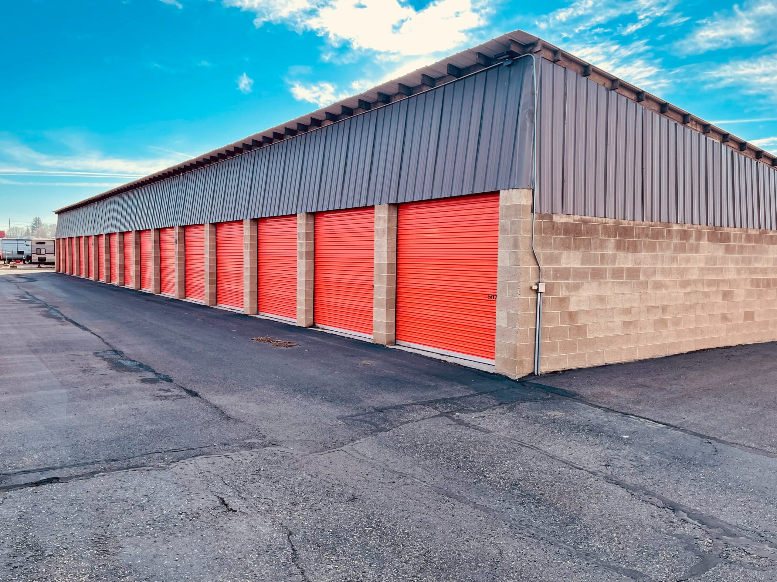 Self storage units in a parking lot equipped with security cameras.